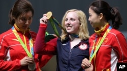 Ginny Thrasher, center, of the United States holds her gold medal for the Women's 10m Air Rifle competition during the award ceremony at the 2016 Summer Olympics in Rio de Janeiro, Brazil, Aug. 6, 2016.