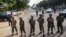 Nigerian army soldiers stand guard as they cordon off a road leading to the scene of a blast at a business district in Abuja, June 25, 2014.