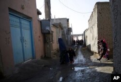 Residents walk on a street of the Qala-e-Walid neighborhood in Kabul, Afghanistan, Feb. 2, 2018.