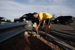A man leaves flowers near the scene of a mass shooting at a shopping complex, Aug. 4, 2019, in El Paso, Texas.