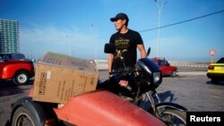 A man loads the sidecar on his motorbike with an air conditioner bought from a shop selling products for dollars in Havana, Oct. 28, 2019. 