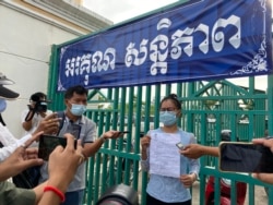 Ney Leak, a former deputy commune chief in Battambang city, shows the summon before she attends a trial hearing at Phnom Penh Municipal Court on November 26, 2020. (Aun Chhengpor/VOA Khmer)