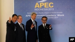 Menlu Indonesia Marty Natalegawa (kanan) dan Menteri Perdagangan Gita Wirjawan (kiri) menyambut Menlu AS John Kerry (dua dari kanan) dan Utusan Perdagangan AS Michael Froman setibanya di Bali untuk menghadiri Forum Kerjasama Ekonomi Asia Pasifik (APEC), 4 Oktober 2013 (AP Photo/Wang Maye-E).
