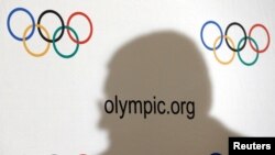 Bayangan Presiden Komite Olimpiade Internasional (IOC) Thomas Bach terpampang di dinding berlogo olimpiade saat konferensi pers usai pertemuan Dewan Eksekutif di Lausanne, Swiss, 8 Desember 2016. (Foto: dok).