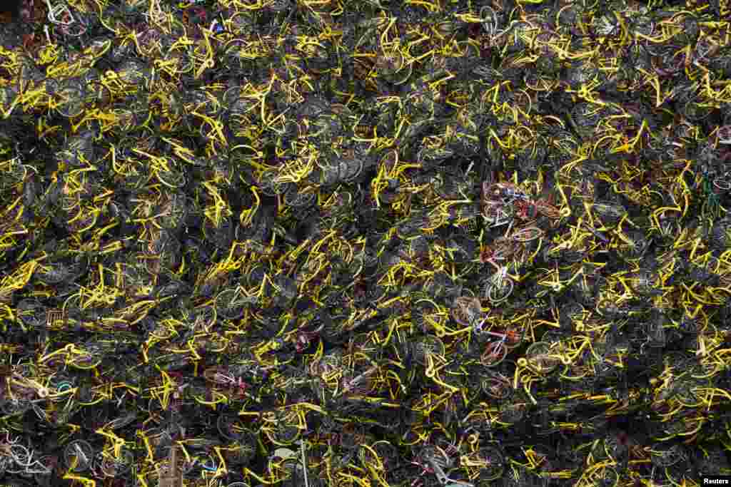 2018年7月8日，在上海部分拆除的房屋废墟中，堆积着各种自行车共享服务公司的自行车。