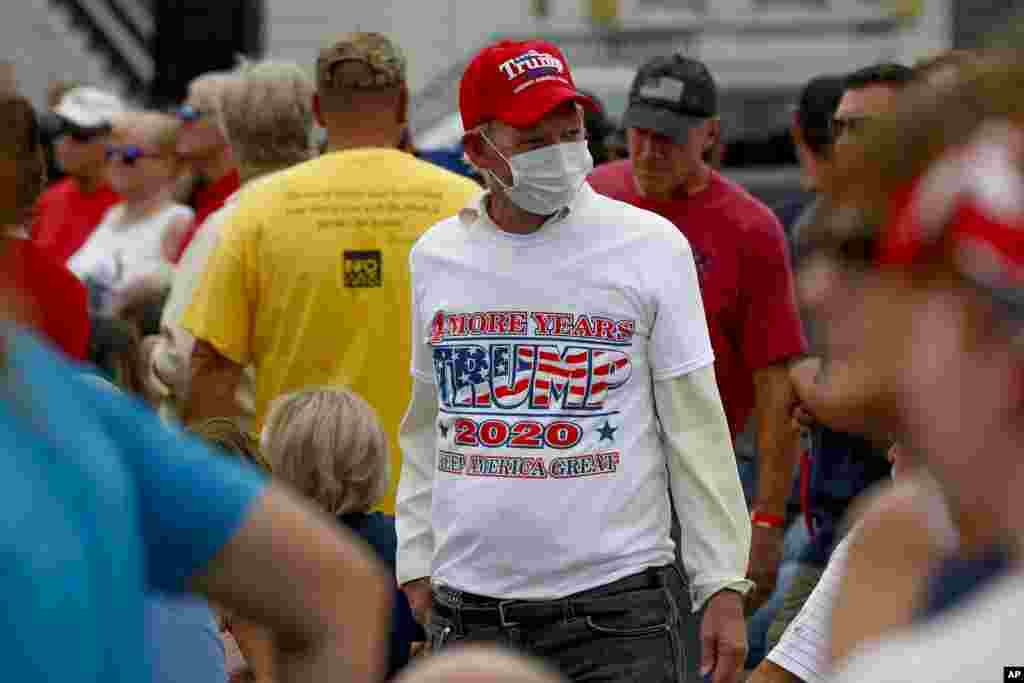 បុរស​ម្នាក់​ពាក់​ម៉ាស ដើរ​ឆ្លងកាត់​ចំណត​រថយន្ត​ មុនពេល​ដែល​លោក​អនុ​ប្រធានាធិបតី Mike Pence បាន​ឡើង​ថ្លែងសុន្ទរកថា ​នៅក្នុង​យុទ្ធនាការ​&laquo;ប៉ូលិស​សម្រាប់ Trump&raquo; នៅ​ឯ​ស្ថានីយ៍​ប៉ូលិស​មួយ​កន្លែង ក្នុង​ទីក្រុង Greensburg រដ្ឋPennsylvania នៅ​ថ្ងៃ​ព្រហស្បតិ៍ ទី៣០ ខែកក្កដា ឆ្នាំ២០២០។ (AP)