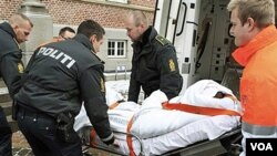 Mohamed Geele ((terbalut kain putih), terdakwa percobaan pembunuhan atas kartunis Kurt Westergaard, diusung ke pengadilan di Aarhus, Denmark.