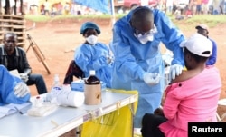 FILE - A Congolese health worker administers Ebola vaccine to a woman who had contact with an Ebola sufferer in the Democratic Republic of Congo, Aug. 18, 2018.