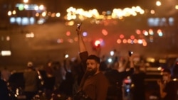 FILE - A man holds up a phone with its flashlight on during a rally of opposition supporters, who accuse Belarusian President Alexander Lukashenko of rigging the polls in his favor, in Minsk, Belarus, Aug. 10, 2020.
