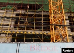 FILE - Laborers work at a construction site in central Phnom Penh, Cambodia, Oct. 21, 2015.