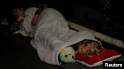 A girl sleeps with her toy as she takes shelter with her family inside a metro station during a Russian military attack in Kyiv, Ukraine, on June 1, 2024.