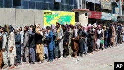 Warga Kabul antre panjang di depan sebuah bank hari Rabu (25/8). 