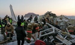 In this photo by the Emergency Situations Ministry of the Republic of Kazakhstan, police and rescuers work on the side of a plane crash near Almaty International Airport, outside Almaty, Kazakhstan, Dec. 27, 2019.