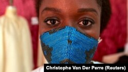 La créatrice de mode Sophie Zinga pose avec un masque facial, qu'elle a conçu comme mesure de protection pour endiguer la propagation du coronavirus, dans son atelier à Dakar, au Sénégal, le 14 mai 2020. 