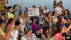 Demonstrators cheer at a city commission meeting in Miami Beach, Florida, Sept. 14, 2016. Opponents want to stop the aerial spraying of the insecticide naled, used to combat the Aedes aegypti mosquito, a potential carrier of the Zika virus.