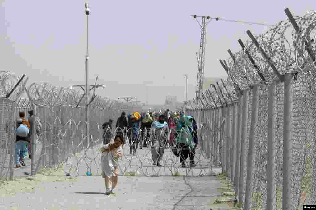 People arrive from Afghanistan at the Friendship Gate crossing point at the Pakistan-Afghanistan border town of Chaman, Pakistan, Aug. 15, 2021.