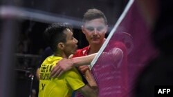 Pebulu tangkis Malaysia, Lee Chong Wei (kiri), berjabat tangan dengan Viktor Axelsen dari Denmark setelah laga tunggal putra Piala Thomas di Bangkok, 23 Mei 2018.