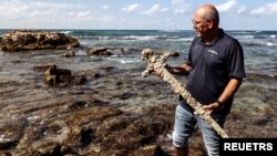 اسرائیلی آثار قدیمہ کے ادارے کے عہدے دار یاکوف شاروت بحیرہ روم سے دریافت ہونے والی قدیم تلوار کے ساتھ۔ 18 اکتوبر 2021