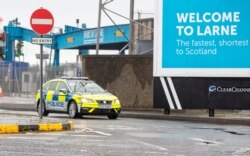 A police vehicle patrols after threats were made to port workers implementing post-Brexit trade checks in Northern Ireland, at the Port of Larne in County Antrim, Feb. 2, 2021.