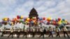 Students hold balloons as they walk past the Independence Monument during celebrations marking the 62nd anniversary of the country's independence from France in central Phnom Penh, Cambodia November 9, 2015. REUTERS/Samrang Pring - RTS631R