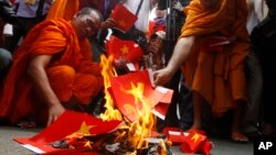 បាតុករ​ខ្មែរ​ដុត​ទង់ជាតិ​វៀតណាម​​ធ្វើ​ពី​ក្រដាស​ ក្នុង​អំឡុង​បាតុកម្ម​មួយ​នៅឯ​ផ្លូវ​ដែល​ត្រូវ​បិត​នៅ​មុខ​ស្ថានទូត​វៀតណាម​ក្នុង​ក្រុង​ភ្នំពេញ​ កាល​ពី​ថ្ងៃ​ពុធ ទី​៨ ខែ​តុលា ឆ្នាំ​២០១៤។