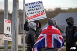 Para pendukung pro-Union berdemonstrasi memprotes Protokol Irlandia Utara yang diterapkan pasca-Brexit, di sebuah jalan menuju Pelabuhan Lame di County Antrim, Irlandia Utara, 6 April 2021. (Foto: Paul Faith/AFP)