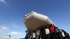 Migrants carry a raft, after being rescued by the Libyan coastguard, at a naval base near the capital Tripoli, Libya. The bodies of 85 migrants have been found washed up on the coast of Libya, a major departure point for the sea crossing to Europe, the Red Crescent said.