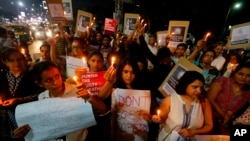Indians hold candles and placards during a protest against two recently reported rape cases, in Ahmadabad, India, April 16, 2018. The outrage was triggered by the rape and murder of an 8-year-old girl in the Indian-controlled portion of Kashmir and the abduction and rape of a teenage girl in India's northern Uttar Pradesh state. 