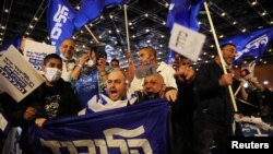 Para pendukung Partai Likud, yang dipimpin Perdana Menteri Benjamin Netanyahu, usai pengumuman hasil jajak pendapat keluar TPS (exit poll) dalam pemilu Israel, di Yerusalem, 23 Maret 2021. (Foto: Ammar Awad/Reuters)