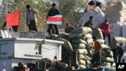 지난 2006년 북-중 접경 도시 단둥에서 북한 무역상들이 중국 선박에 교역품을 싣고 있다. (자료사진)