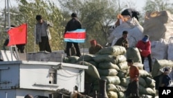 지난 2006년 북-중 접경 도시 단둥에서 북한 무역상들이 중국 선박에 교역품을 싣고 있다. (자료사진)