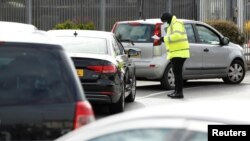 People queue in their cars at an NHS drive through coronavirus disease (COVID-19) testing facility in the car park of Ikea in Wembley, Britain, April 1, 2020.