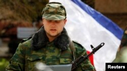 A member of a pro-Russian self defence unit swears an oath to the pro-Russia Crimea regional government in Simferopo, March 13, 2014.