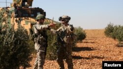 U.S. and Turkish soldiers discuss details during the first-ever combined joint patrol in Manbij, Syria, Nov. 1, 2018. (Courtesy: Arnada Jones/U.S. Army/Handout) 