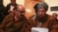 FILE- Maulana Sami ul-Haq (R), one of the Taliban negotiators, and Irfan Siddiqui, a government negotiator, discuss a joint statement before a news conference in Islamabad, Pakistan, Feb. 6, 2014.