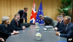 FILE - European Council President Donald Tusk, right, meets with British Prime Minister Theresa May, left, during a bilateral meeting on the sidelines of an EU summit in Brussels, Belgium, June 22, 2017.