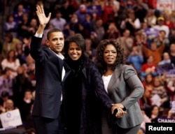 FILE - Democratic presidential candidate U.S. Senator Barack Obama, left, his wife Michelle, center, and talk show host Oprah Winfrey wave to the crowd at a campaign rally in Manchester, New Hampshire, Dec. 9, 2007.
