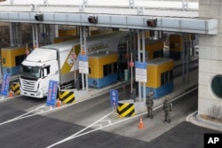 A South Korean truck heads to the North Korean city of Kaesong as South Korean Army soldiers stand guard at the customs, immigration and quarantine office near the border village of Panmunjom, in South Korea, Thursday, Feb. 11, 2016.