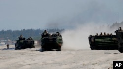 FILE - Amphibious Assault Vehicles, carrying American and Philippine troops, are seen on a beach during "Balikatan 2019" exercices, April 11, 2019, off San Antonio, Zambales province, northwest of Manila, Philippines. 