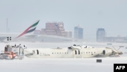 18 فروری 2025 کو ٹورانٹو، اونٹاریو میں ٹورنٹو پیئرسن انٹرنیشنل ایئرپورٹ پر لینڈنگ کے دوران ڈیلٹا ایئر لائنز کے طیارے کے الٹ جانے کے ایک دن بعد تفتیش کاروں کے ملبے کا جائزہ لے رہے ہیں۔