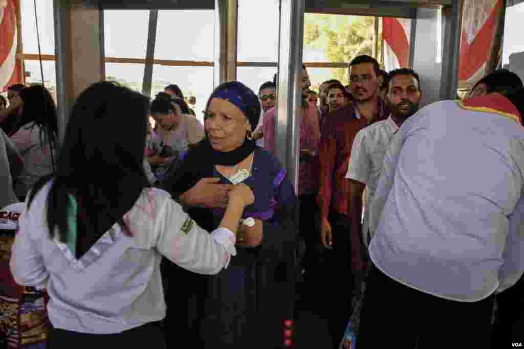 Teams help check people coming to attend the event of Virgin Mary at the Dronka mountain foot in Assiut, Egypt, August 20, 2017. (H. Elrasam/VOA)