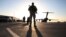 FILE - A solider stands guard near a military aircraft in Kandahar, Afghanistan.