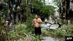 បុរសម្នាក់ឈរលើដងផ្លូវដែលមានគំនរមែកឈើបាក់ធ្លាក់ពេញដងផ្លូវ បន្ទាប់ពីព្យុះទីហ្វុង Molave បានបោកបក់ចំខេត្ត Quang Ngai ប្រទេសវៀតណាម ថ្ងៃទី២៨ ខែតុលា ឆ្នាំ២០២០។