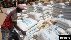 A man carries sacks of food aid delivered by the United Nations Office for the Coordination of Humanitarian Affairs and world food program in the village of Makunzi Wali, Central African Republic, April 27, 2017.