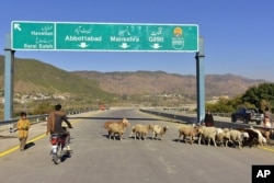 FILE - A Pakistani motorcyclist drives on a newly built Pakistan-China Silk Road in Haripur, Pakistan, Dec. 22, 2017.