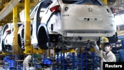 资料照：中国湖北武汉的东风集团本田汽车公司的工人在生产线上工作。（2020年3月16日）