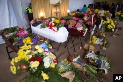 Flower-covered coffins of seven people, who died during the eruption of the Volcan de Fuego, which in Spanish means Volcano of Fire, stand in the main park of the town San Juan Alotenango, Guatemala, Monday, June 4, 2018.
