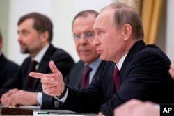 Russian President Vladimir Putin, accompanied by Russian Foreign Minister Sergei Lavrov, second from right, speaks during a meeting with Secretary of State John Kerry at the Kremlin in Moscow, Russia, Thursday, March 24, 2016.