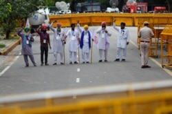 Petani meneriakkan slogan-slogan dalam aksi protes menentang undang-undang pertanian, di dekat gedung parlemen di New Delhi, India, 22 Juli 2021. (REUTERS/Adnan Abidi)