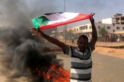 A protester waves a flag during what the information ministry calls a military coup in Khartoum, Sudan, October 25, 2021.
